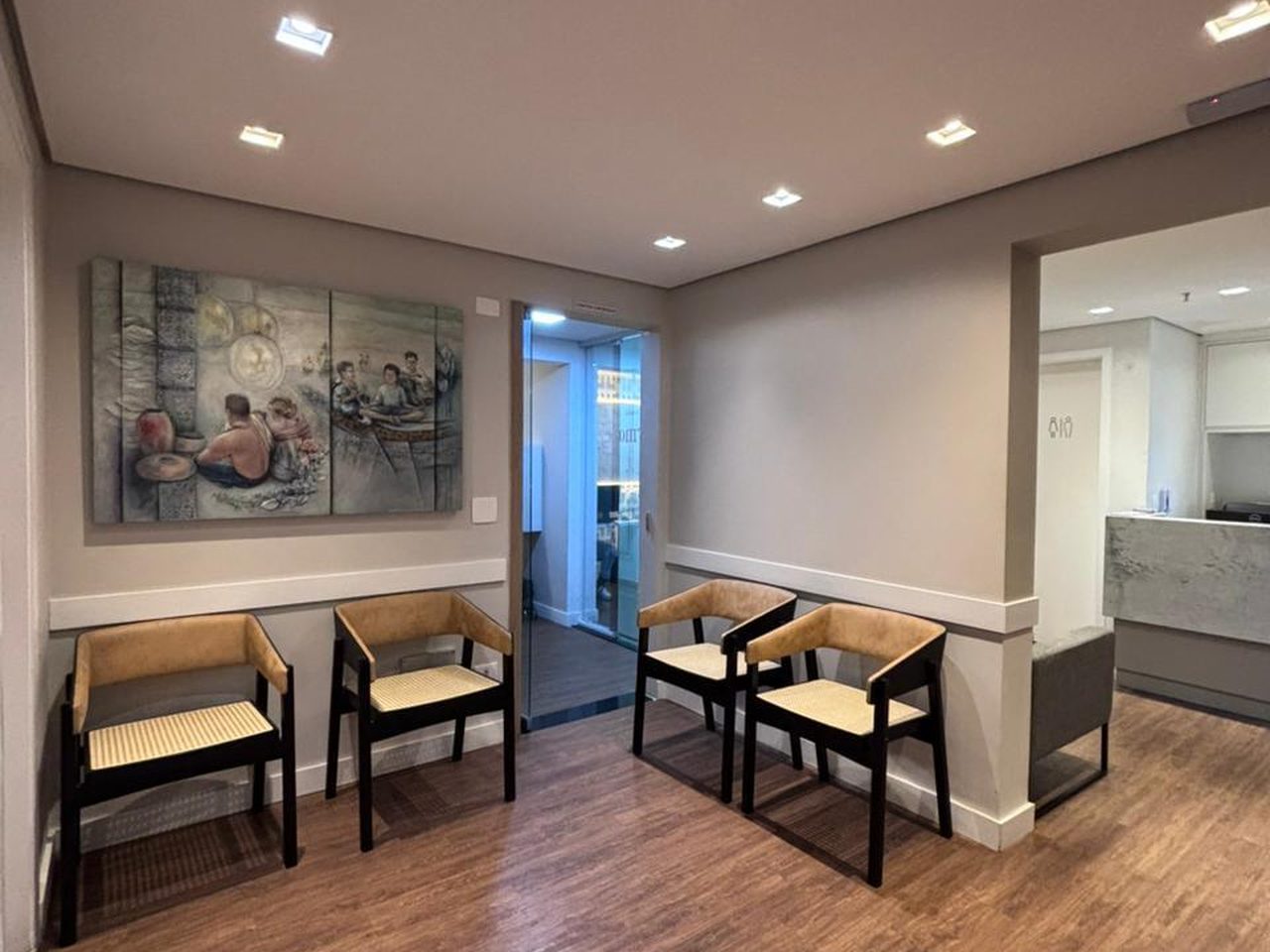 Sala de espera com poltronas e quadro